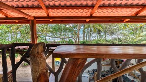 A wooden structure with a tiled roof, a wooden table, and a bird sculpture. - El Deseo Serendipity Hotel (Colorado)