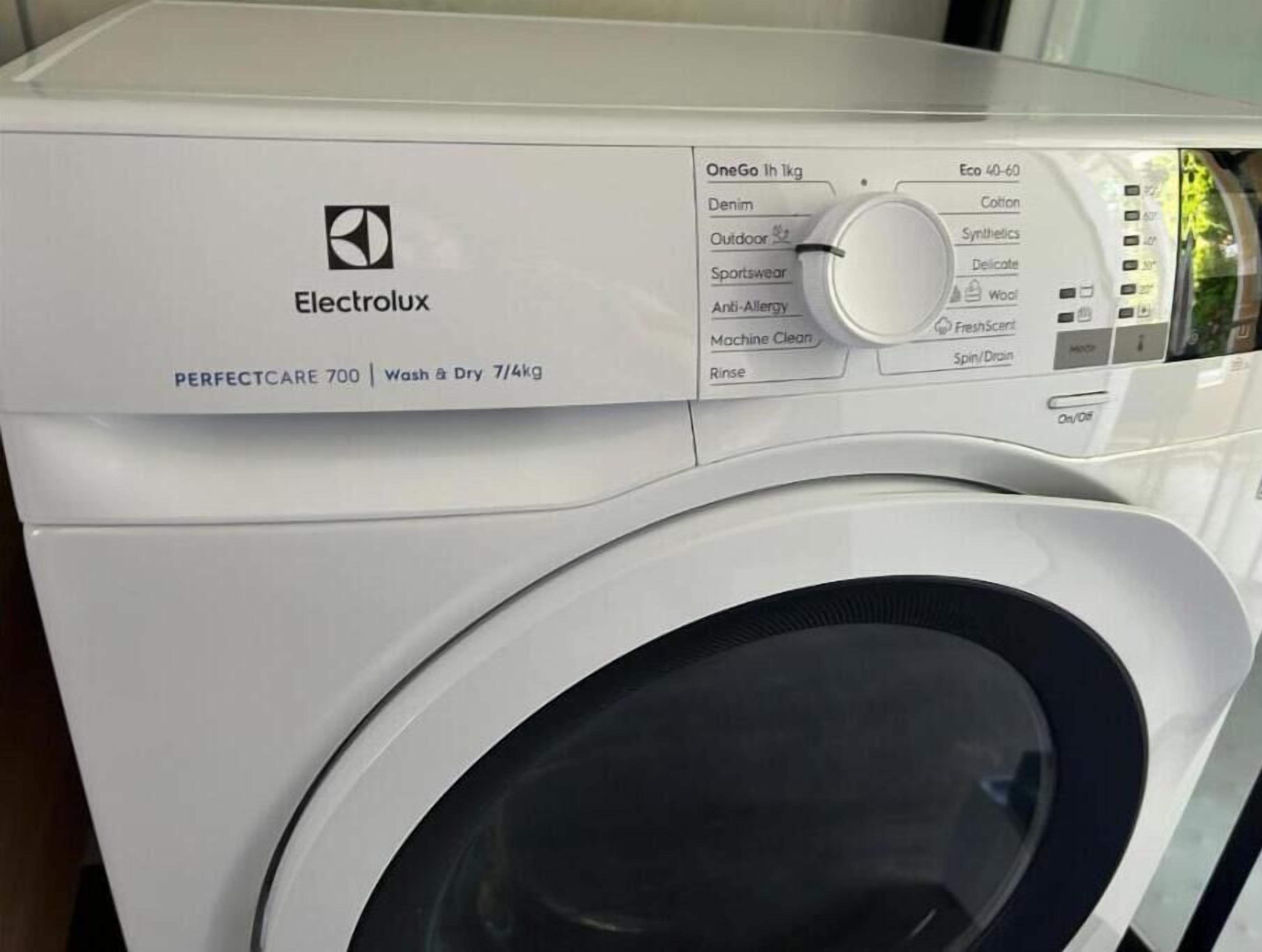Eine Frontansicht einer Electrolux PERFECTCARE 700 Waschmaschine mit einer Bedieneinheit, die verschiedene Einstellungen bietet.