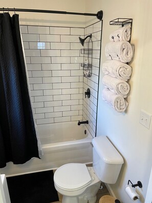 Ein Badezimmer mit einer weißen Badewanne, einer Toilette und einer Duschkabine.