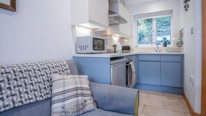 A compact kitchen with a microwave, toaster, and sink. - Tor Bay Cottage - 1 Bedroom - Parkmill (Swansea)