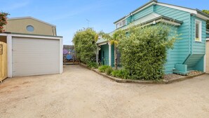 A residential area with two houses, one with a closed garage and the other with a visible front door. - Price on the Beach 2c Pet-Friendly Steps to Beach (Torquay)