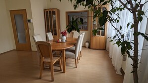 En matplats med ett träbord, sex stolar och en krukväxt.