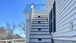 Eine Treppe führt zu einem Haus mit einer Metallbedachung und einer weißen Außenwand.