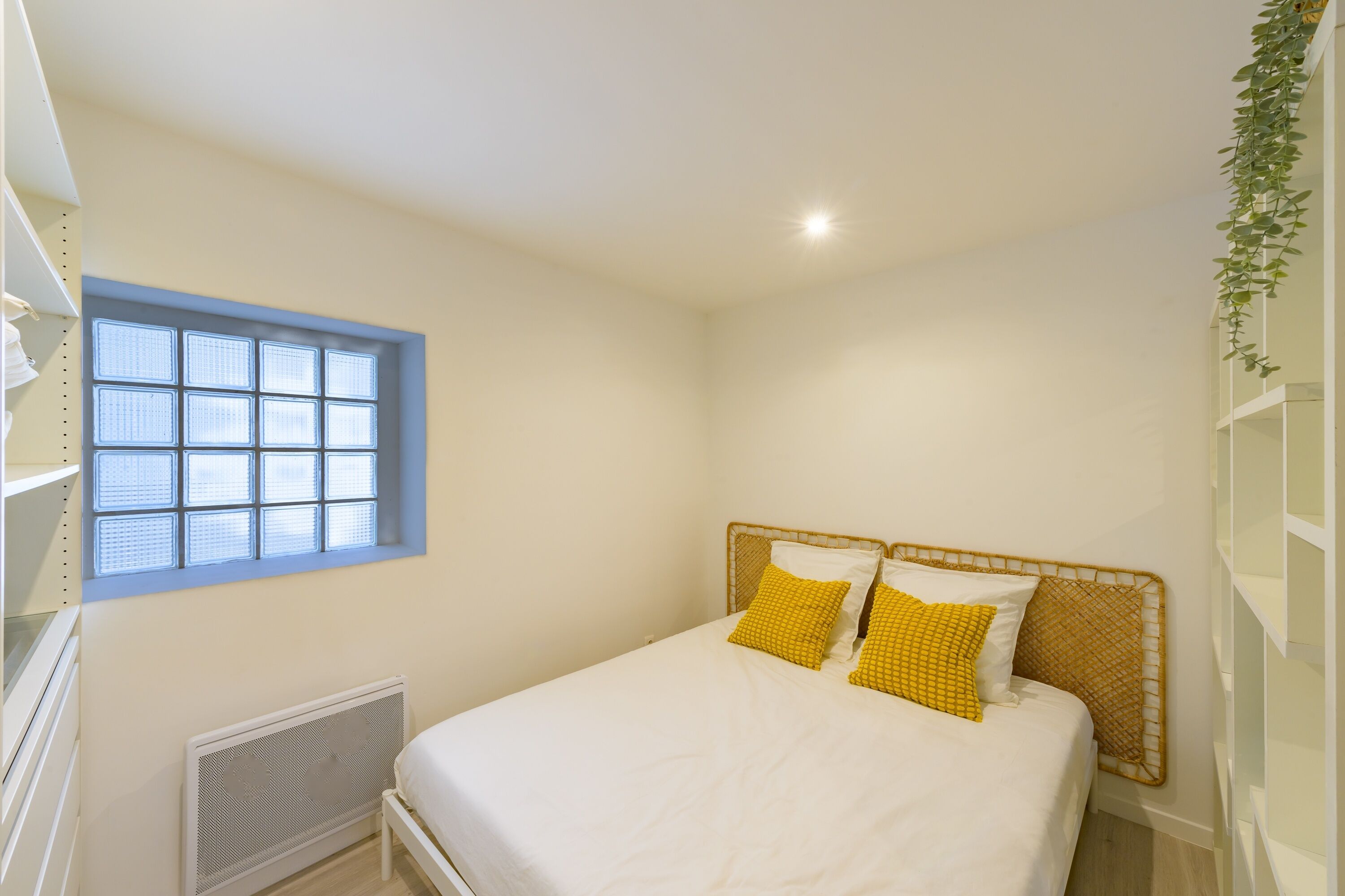A bedroom with a bed, a window, and a radiator.