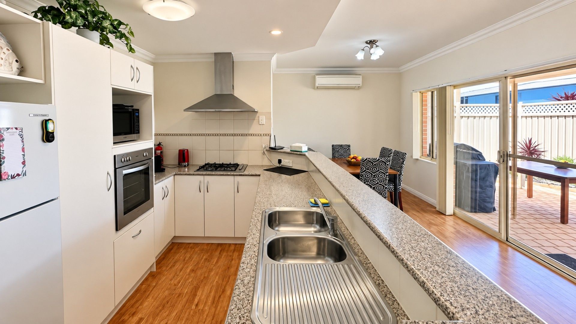 A modern kitchen with stainless steel appliances, a built-in oven, and a large island with a sink.