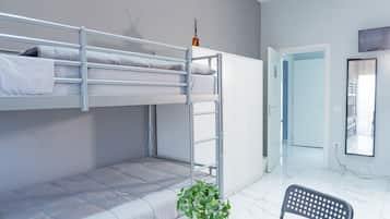 Ein Schlafraum mit Etagenbett, einer Leiter, einem Stuhl und einem Blumentopf.