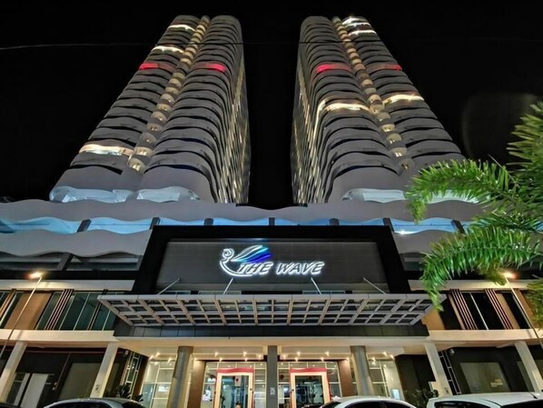 A hotel with a prominent 'The Wave' sign, featuring a modern architectural design with two tall buildings and a wave-like structure at the entrance. - The Wave Residence (Malacca City)