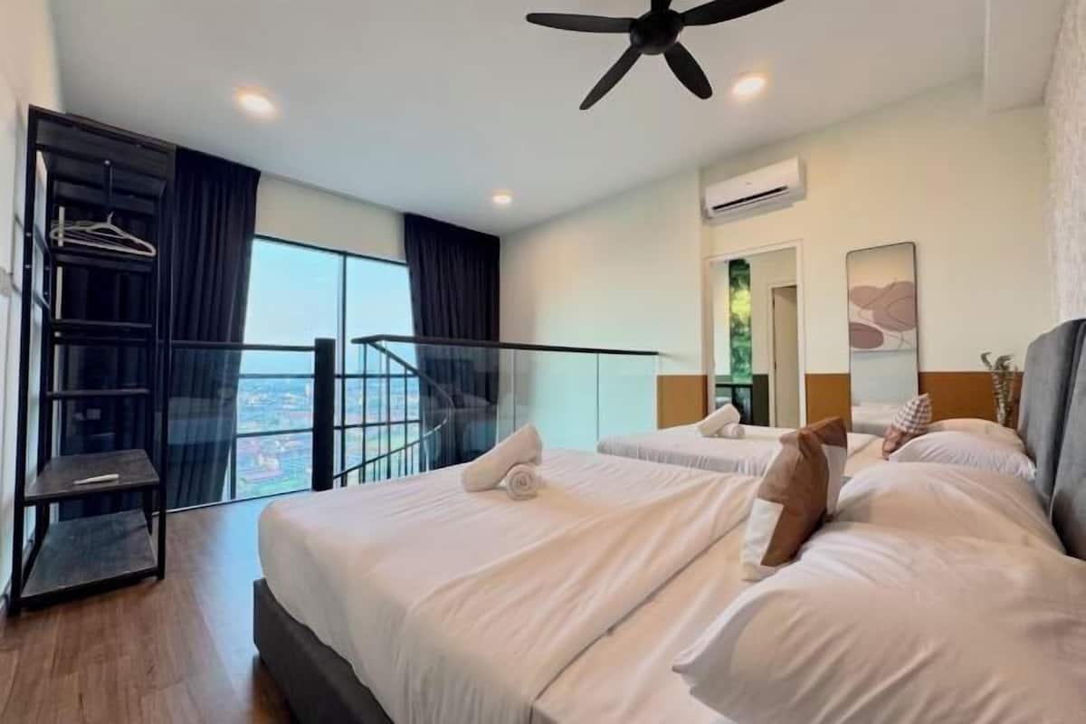 A hotel room with two beds, a balcony with a view, a ceiling fan, and an air conditioning unit.