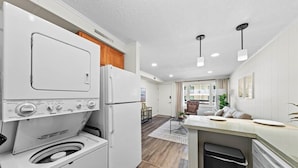 Una cocina compacta con lavadora, refrigerador y lavavajillas.