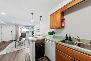 Enjoy cooking in this well-equipped kitchen with a stainless steel sink, dishwasher, and ample countertop space.