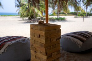 Na praia, areia branca, espreguiçadeiras, guarda-sóis 