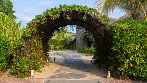 An archway covered in greenery leading to a pathway. - El Origen Villas & Spa Puerto Escondido (San Pedro Mixtepec)