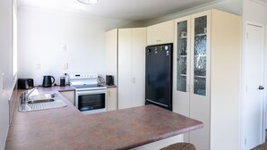 A compact kitchen with a sink, stove, and black refrigerator. - Fantail Cottage - 35mins to Raglan &15 mins to shopping centre.
Farm outlook (Whatawhata)