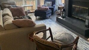 A spacious living room with a large window, a fireplace, and a cozy seating area. - Newly renovated Townhouse walking distance to Mt.Snow base lodge.  (Dover)