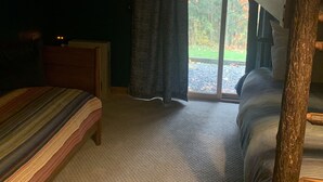 A room with a bunk bed, a single bed, a framed picture on the wall, and a window with curtains. - Newly renovated Townhouse walking distance to Mt.Snow base lodge.  (Dover)