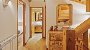 Ein Flur mit Holzboden, einem Heizkörper und einer Holztreppe mit Buchstabenblöcken.