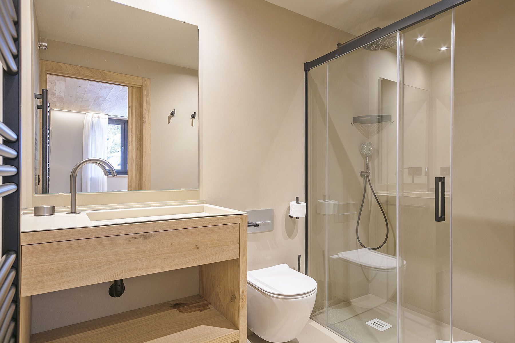 Une salle de bain moderne avec une douche à parois de verre, un meuble-lavabo en bois et des toilettes.