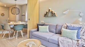 Een moderne woonkamer met een bank, een eettafel en stoelen.
