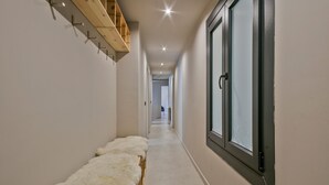 A narrow hallway with a wooden bench, a window with a black frame, and a door with a handle. - Luderna - Apartamento con terraza Montanero (Vielha)