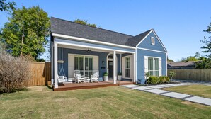 A two-story house with a covered porch, a lawn, and a wooden fence. - Beautiful Retreat Near Historic Downtown McKinney (McKinney)
