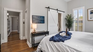 A bedroom with a bed, a desk, a lamp, and a painting. - Beautiful Retreat Near Historic Downtown McKinney (McKinney)