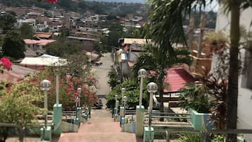 Escadaria descendo para uma área residencial com casas e céu claro.