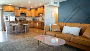 A modern kitchen with wooden cabinets, stainless steel appliances, and a bar area.