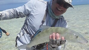 A person holding a fish in clear shallow water. - Bahamas Fishing Lodge Hotel
Acklins Island (Salina Point)