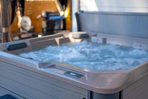 Ein Whirlpool mit Bedienfeld, umgeben von einer Holterrasse.