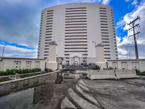 Un bâtiment cylindrique et imposant, doté d’une entrée centrale et d’une allée menant à une porte.