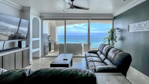 A modern living room with a large TV, comfortable seating, and a view of the ocean. - MarYSo- Condo-BeachAccess-3BR-6th FLR-Rosarito (Playas de Rosarito)
