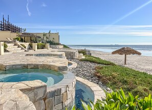 Un espace piscine offrant une vue sur la plage et l’océan.