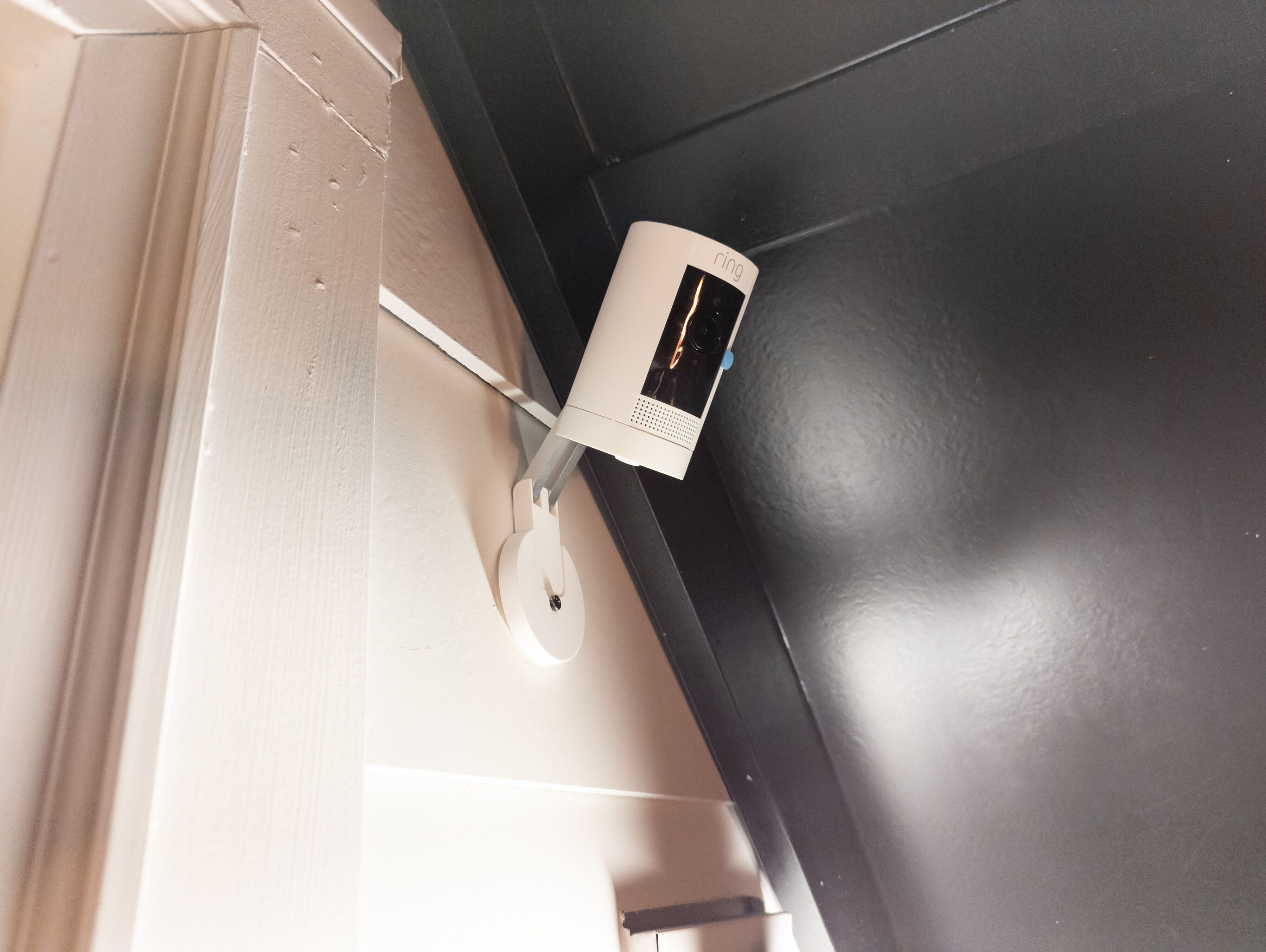A white charging device with a screen on a black surface, possibly a desk or table.