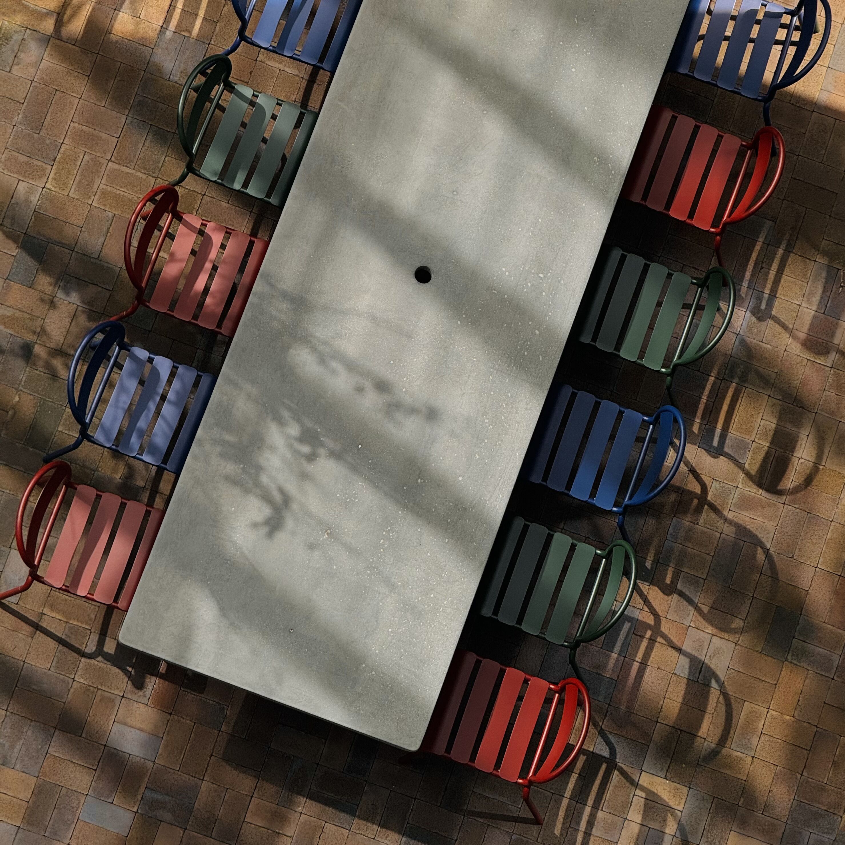 A rectangular outdoor table with chairs around it.