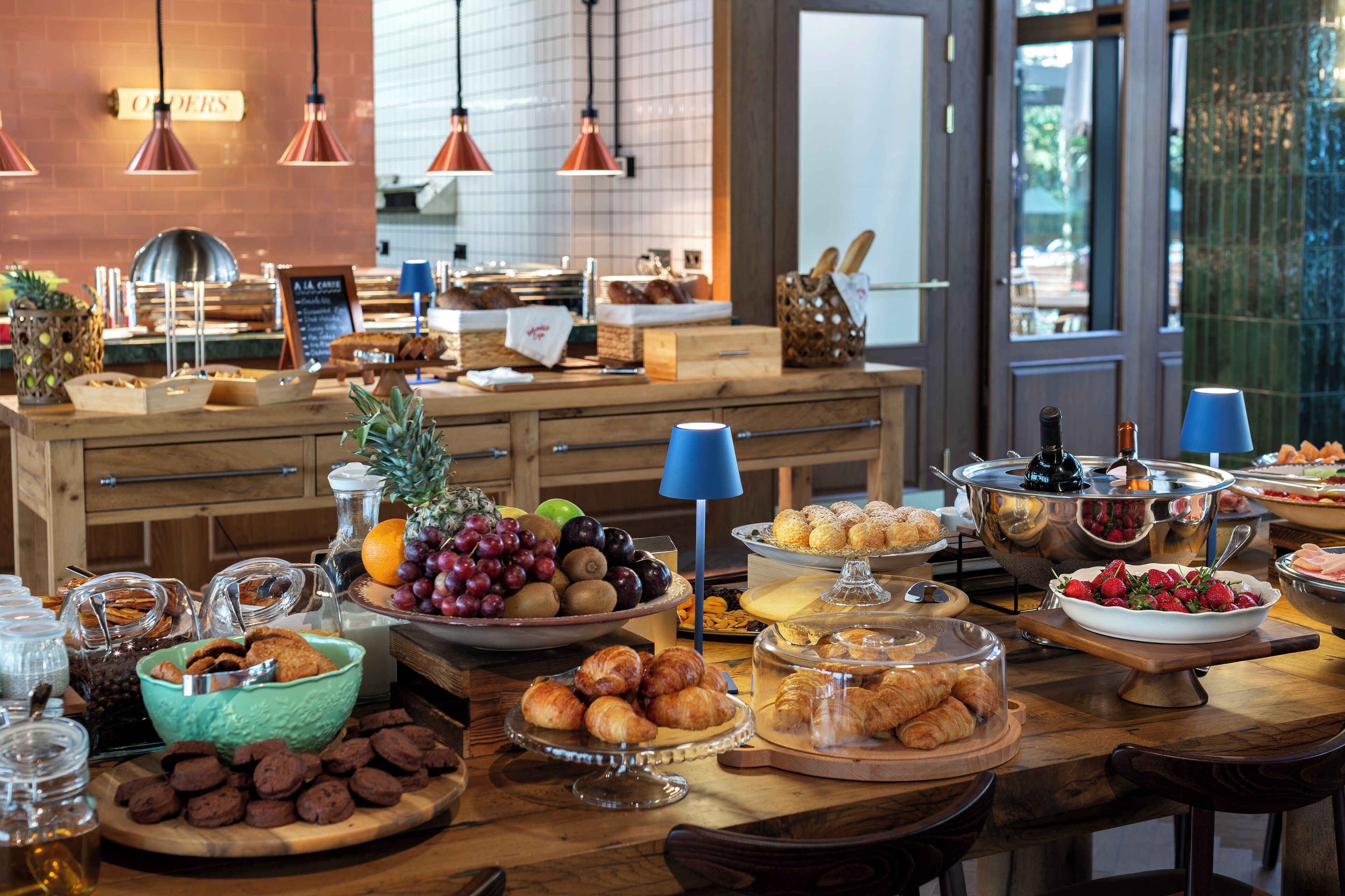A buffet with various food items and a wooden counter.