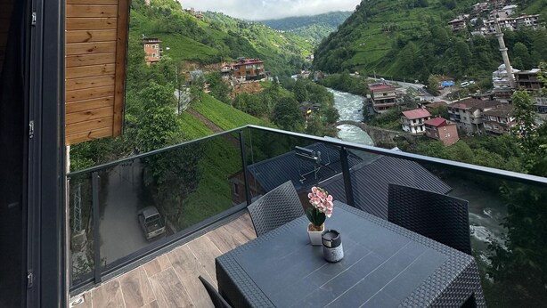 A balcony with a view of a river and green hills. - Dereüstü ve Gökçe Bungalov (Ardesen)
