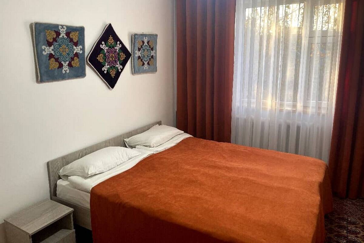 A bedroom with a bed, a nightstand, and three wall-mounted artworks.