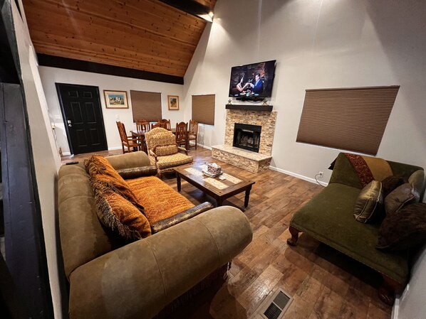 A cozy living room with a fireplace, a television mounted on the wall, and a dining area with wooden furniture. - Beauty in the pines!
Flagstaff Az (Flagstaff)
