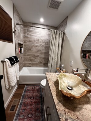 A modern bathroom with a bathtub, a vanity with a unique sink design, and a shower area. - Beauty in the pines!
Flagstaff Az (Flagstaff)