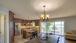 Una cocina amplia con armarios de madera, una isla central y un comedor con mesa y sillas.