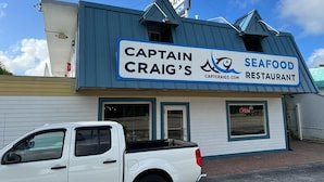 En restaurang som heter Captain Craig's Seafood Restaurant, med en blå och vit fasad och en skylt.
