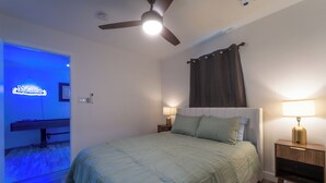 A bedroom with a bed, two bedside tables, a ceiling fan, and a nightstand with a lamp. - Stylish Group Retreat • Hot Tub • Game Room • Yard (Austin)