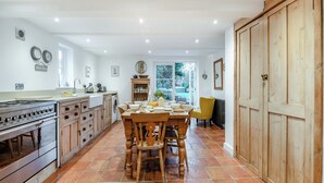 Una cocina amplia con comedor, armarios de madera y un ventanal grande.