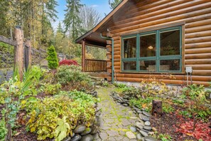 A log cabin with a stone pathway leading to a wooden deck. - Private, ocean view cabin next to ONP; hot tub/game-room (Port Angeles)