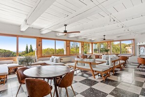 A spacious dining area with large windows, wooden furniture, and a checkered floor. - Villa "Paradis" with Sea View, Private Pool and Wi-Fi (les Issambres)