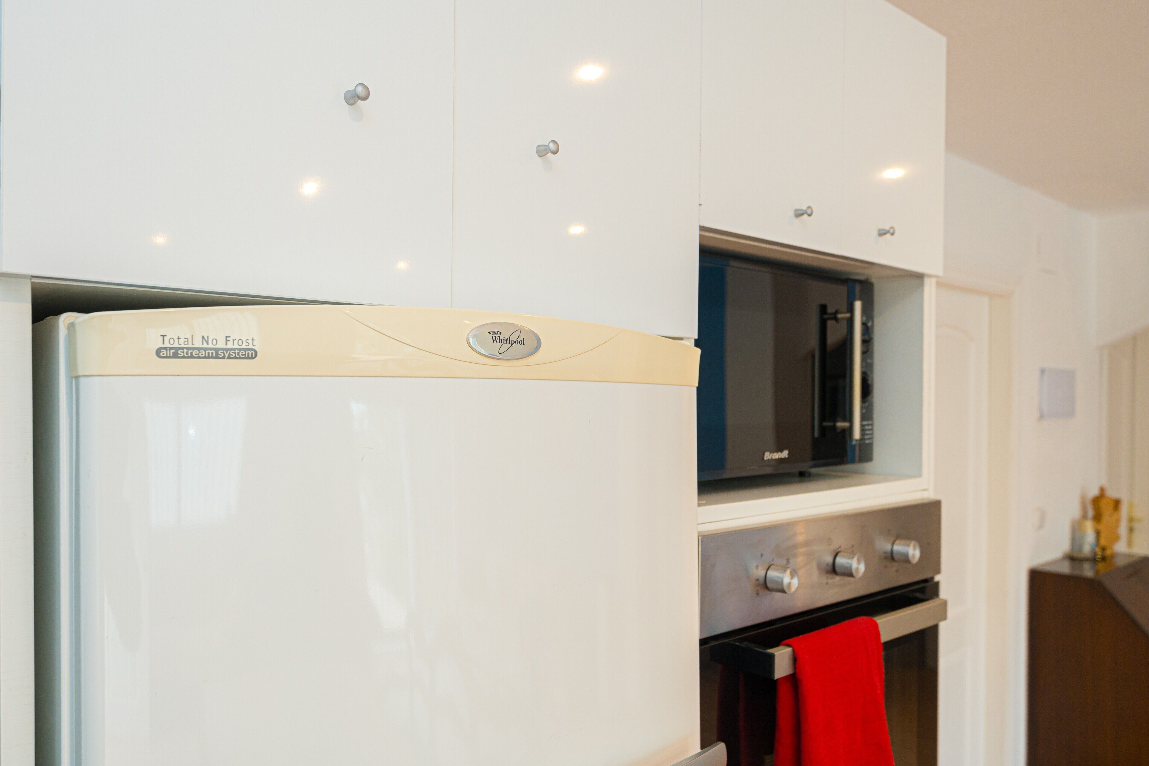 A kitchen with a refrigerator, microwave, and oven.