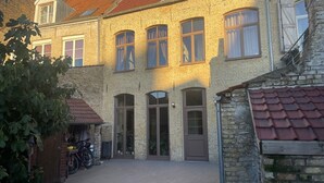 Ein zweistöckiges Gebäude mit Ziegelverkleidung, großen Fenstern und einem Ziegeldach.