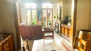Ein gemütliches Zimmer mit Sofa, Esstisch und Küchenzeile mit Herd und Schränken.