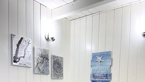 A dining area with a white table and four chairs. There are three framed cityscape photos on the wall. - Cozy one bedroom across from the beach #2 (North Myrtle Beach)