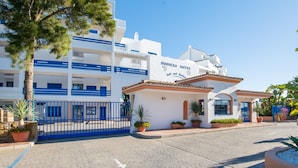 Un hôtel à la façade blanche, agrémentée de touches de bleu, et sur lequel on peut lire l’inscription « DUQUESESA SUITES ».